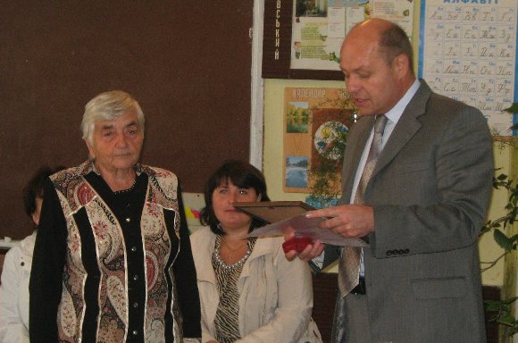 Валентин Королюк вручає грамоту обласної ради Ніні Шишко